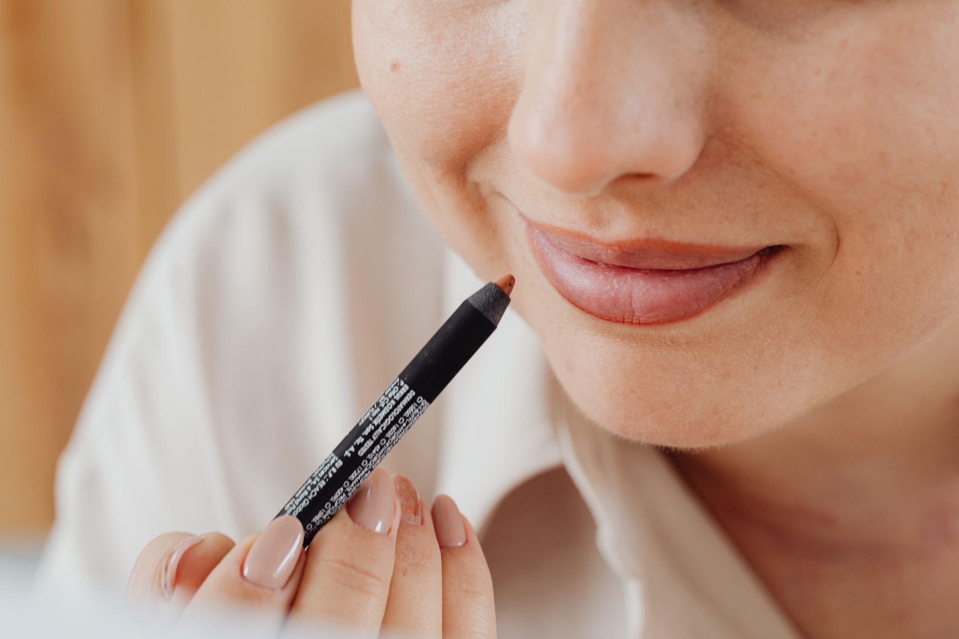 Close-up image of a woman applying lip liner with precision, highlighting beauty and self-care.